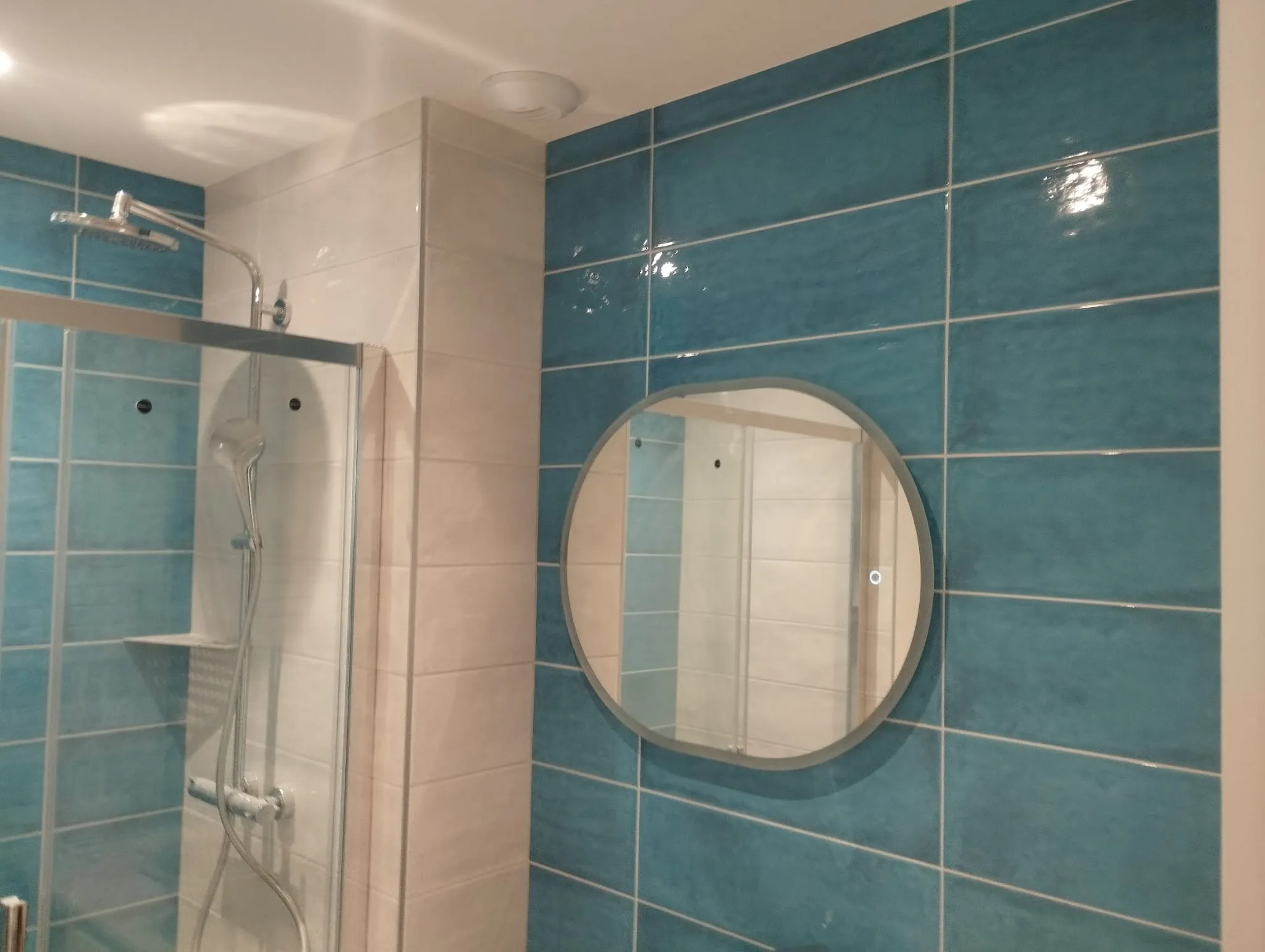 Salle de bain bleu canard : douche et miroir rond